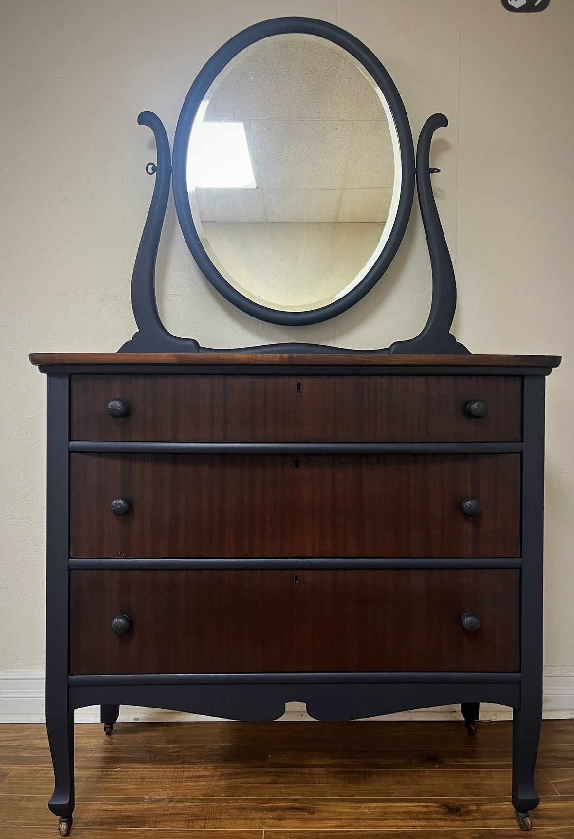 Charcoal and walnut dresser with an oval mirror