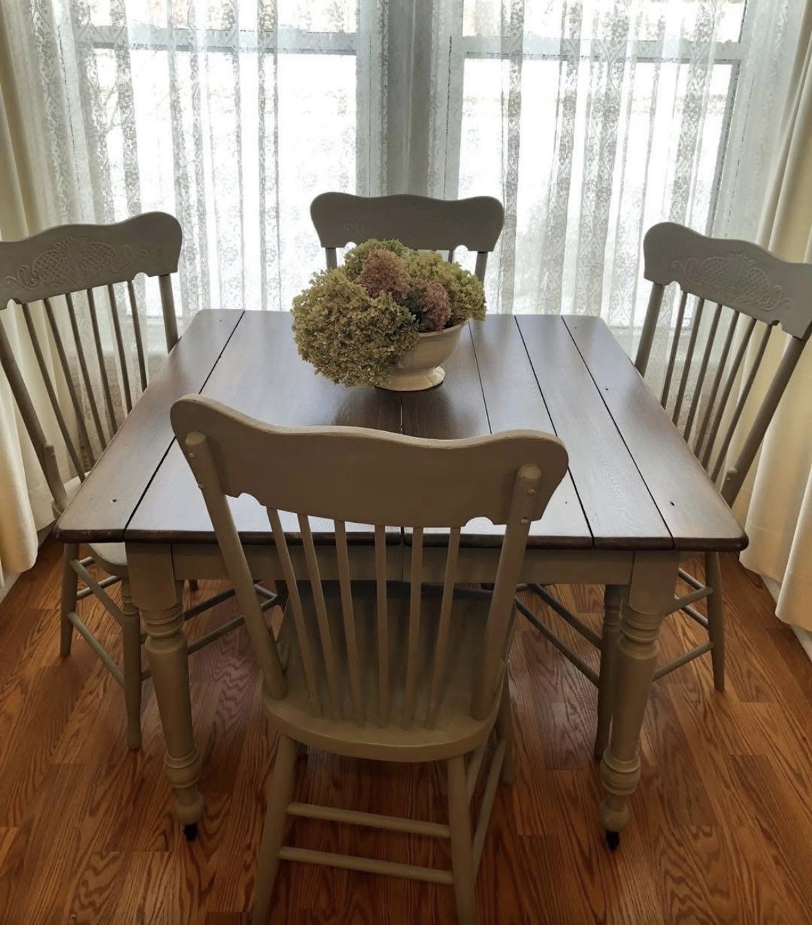 Farmhouse dining table with a dark wood top and painted base and chairs