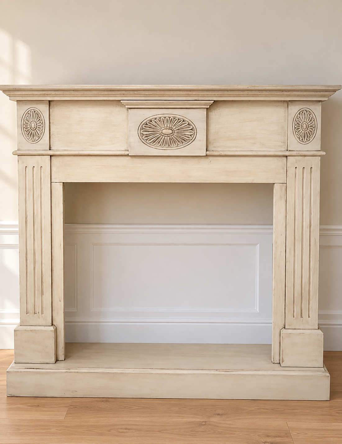 Cream fireplace mantel with carved oval medallions, refinished by Tricia's Treasures