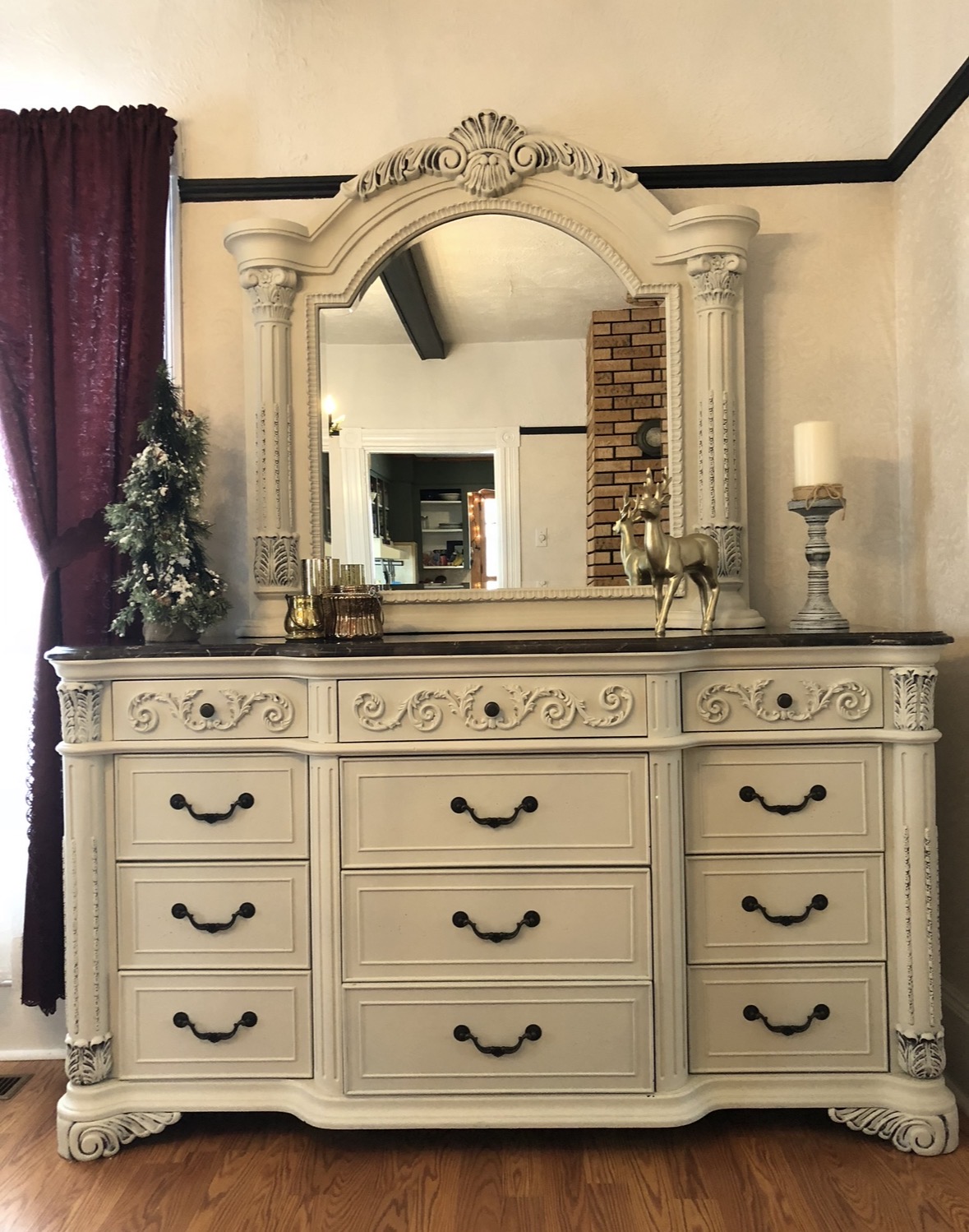 Large ornate cream dresser with a dark wood top and mirror